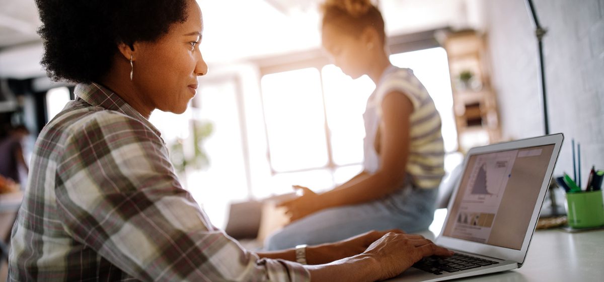 Mother working with daughter in background