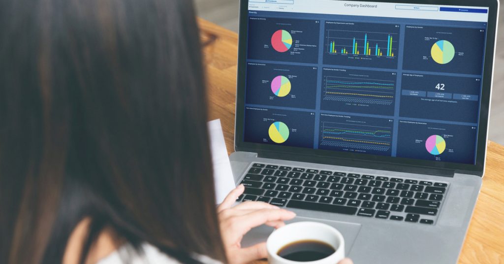 Employee Cycle HR analytics dashboard software on a laptop being used by a businesswoman drinking coffee