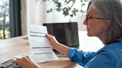 HR budgeting businesswoman using a calculator at her desk