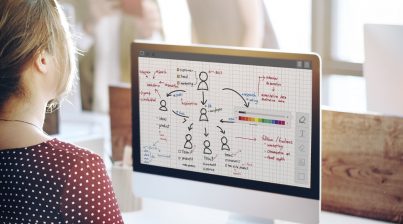 7 tips for workforce headcount planning in 2022- photo of HR leader planning organizational chart in front of computer in the office