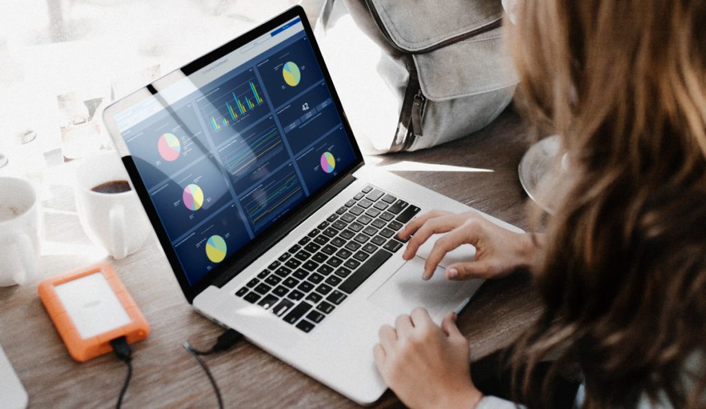 HR professional viewing the diversity dashboard in the Employee Cycle HR analytics and data visualization software on her Macbook with coffee