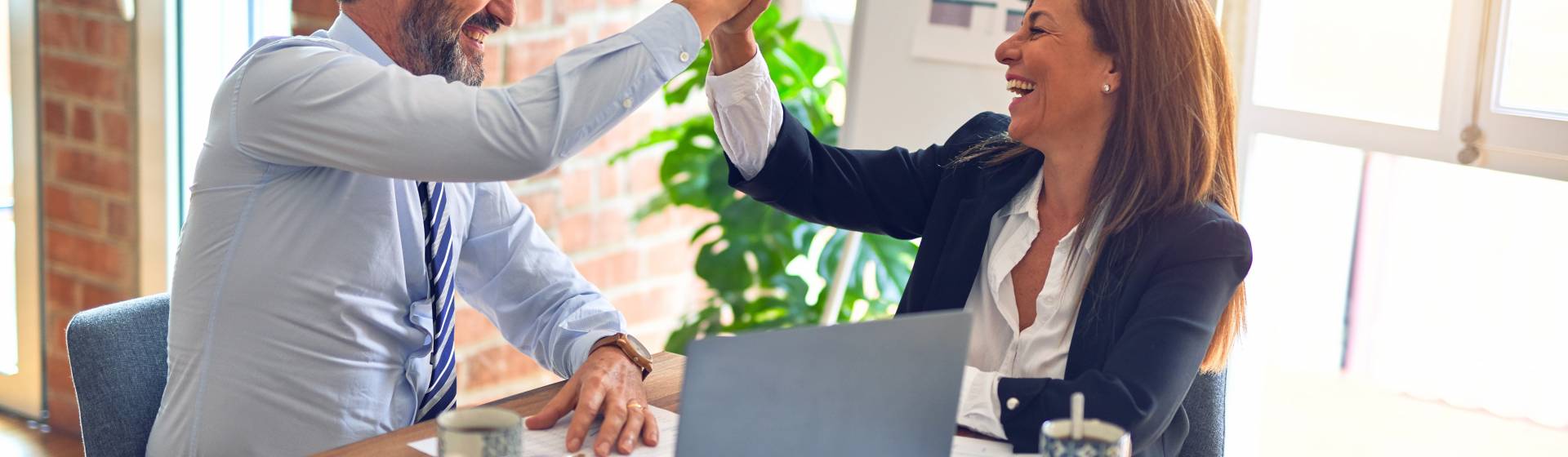 Two people in office giving high fives