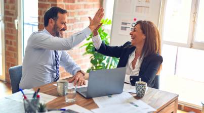 Two people in office giving high fives