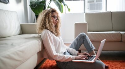Woman working on laptop sitting on the floor