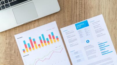 Printed analytics reports next to laptop