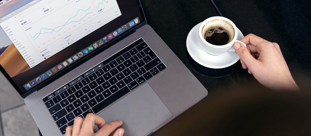 Data dashboard on a laptop with cup of coffee to the side