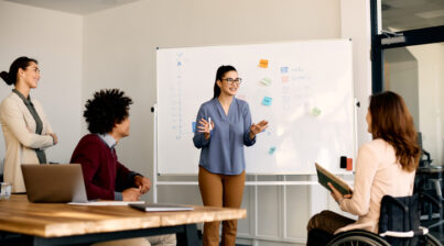 Young presenter talking to a diverse team in the office